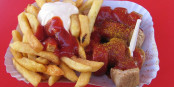 So wird Currywurst mit Fritten rot-weiss bei Konnopke's in Berlin serviert - stilecht! Foto: User Orderinchaos / Wikimedia Commons / CC-BY-SA 3.0